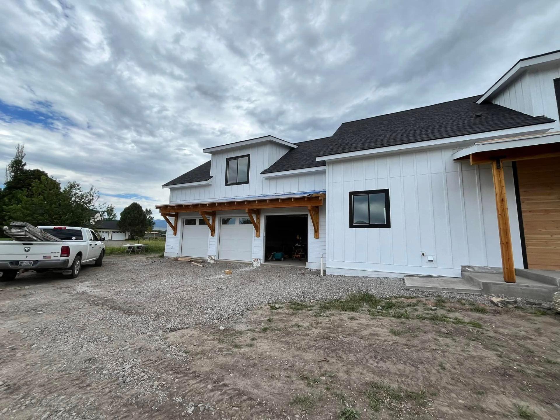 Two-tone white farmhouse with cedar accents painted by Treeline Painting