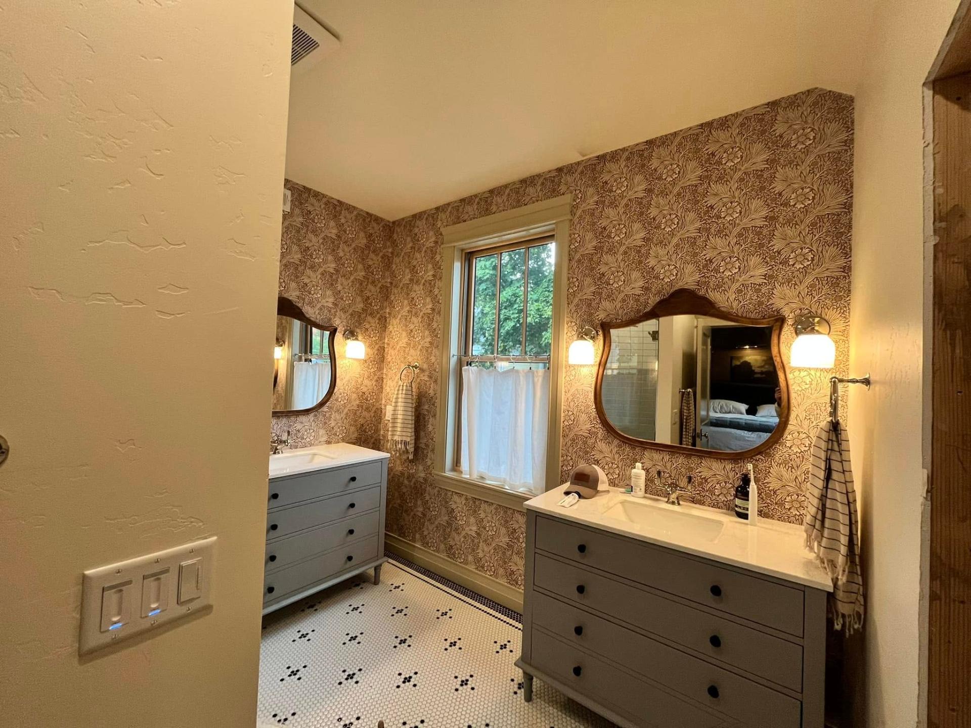 Double vanity bathroom with floral wallpaper and crisp painted trim by Treeline Painting