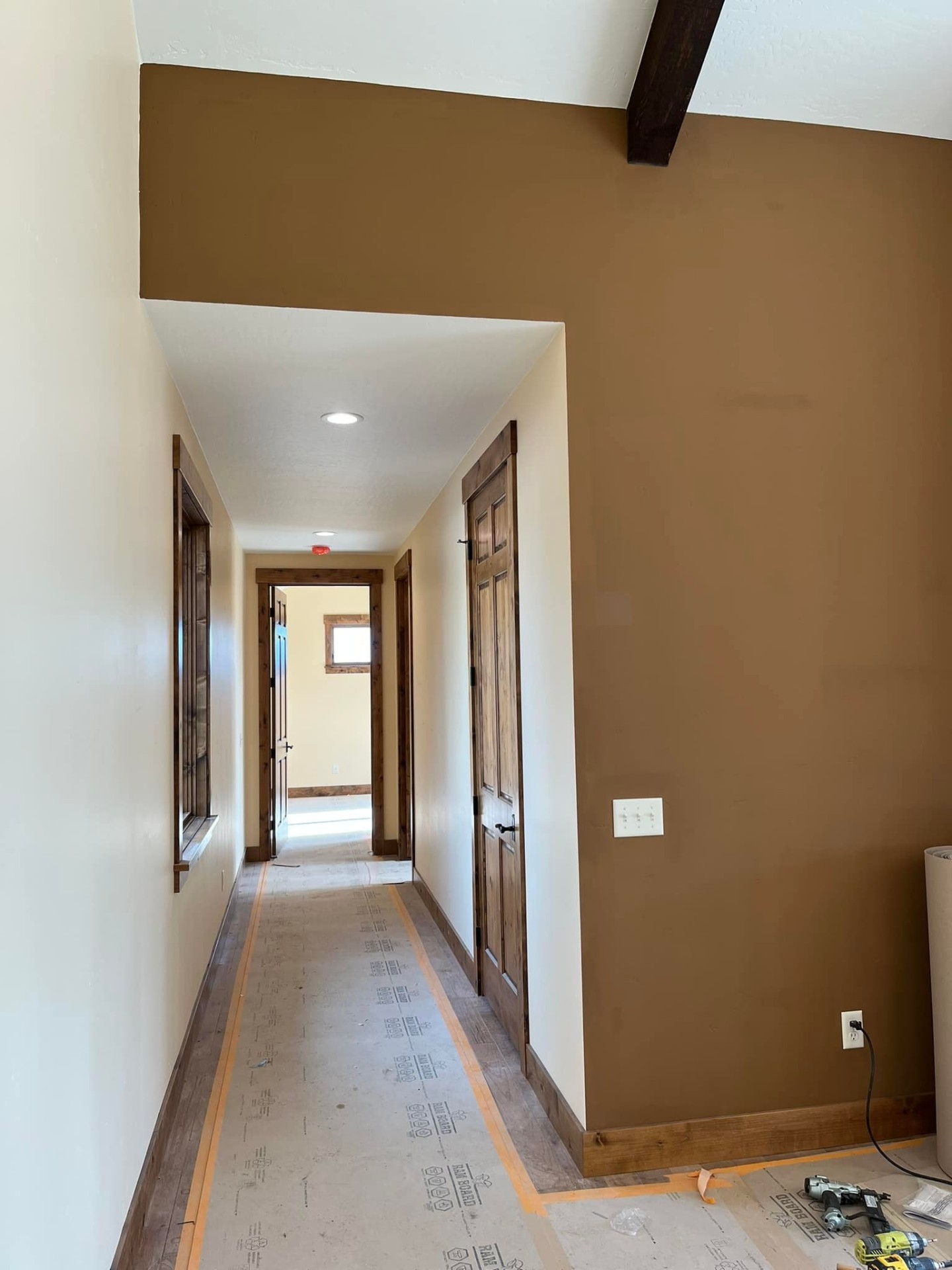 Warm caramel accent wall and cream hallway painted by Treeline Painting