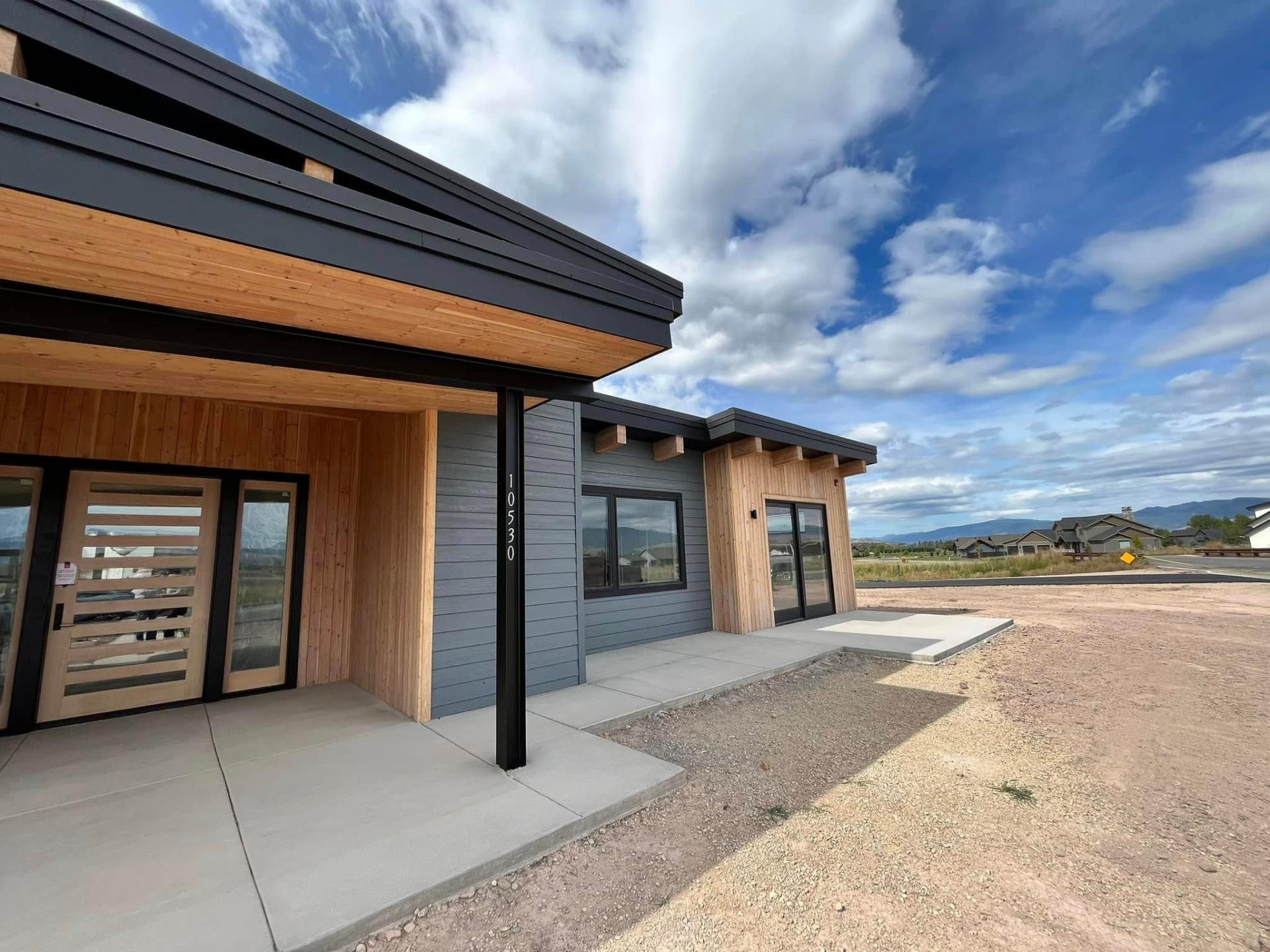 Close-up of modern home exterior with cedar soffits and dark siding by Treeline Painting