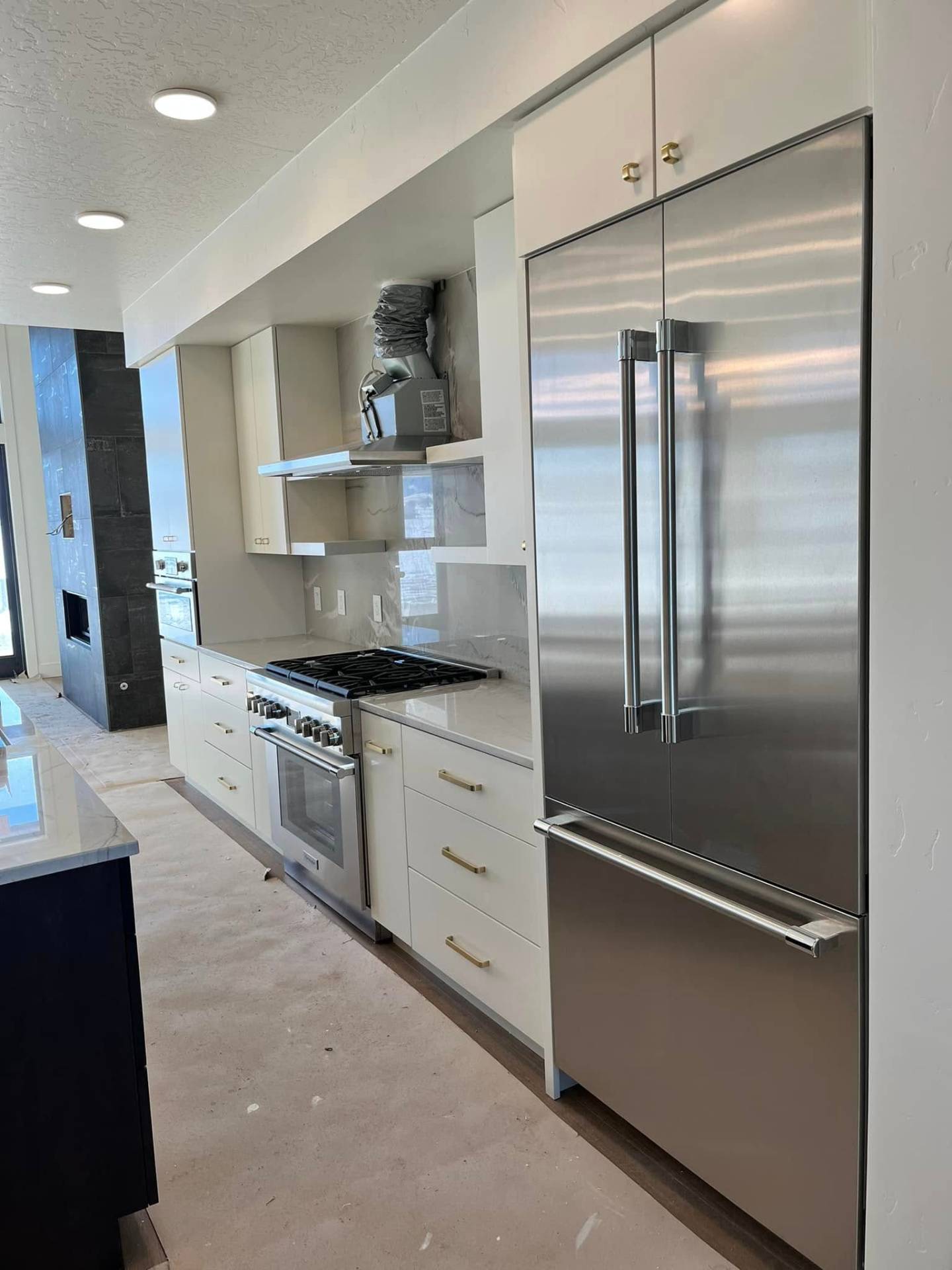 Modern white kitchen cabinets with brass hardware finished by Treeline Painting