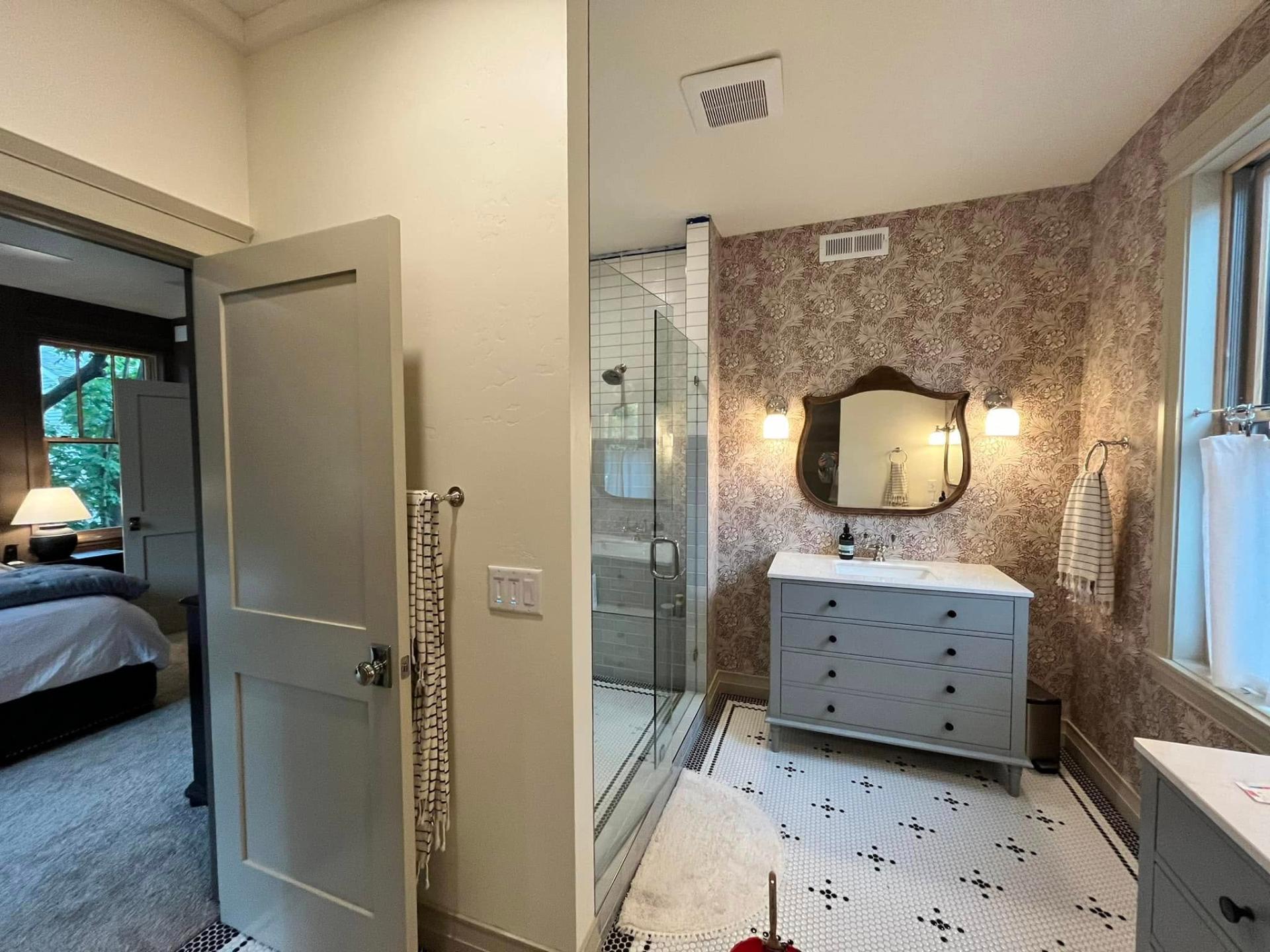 Bathroom with wallpaper accent wall and freshly painted gray trim by Treeline Painting