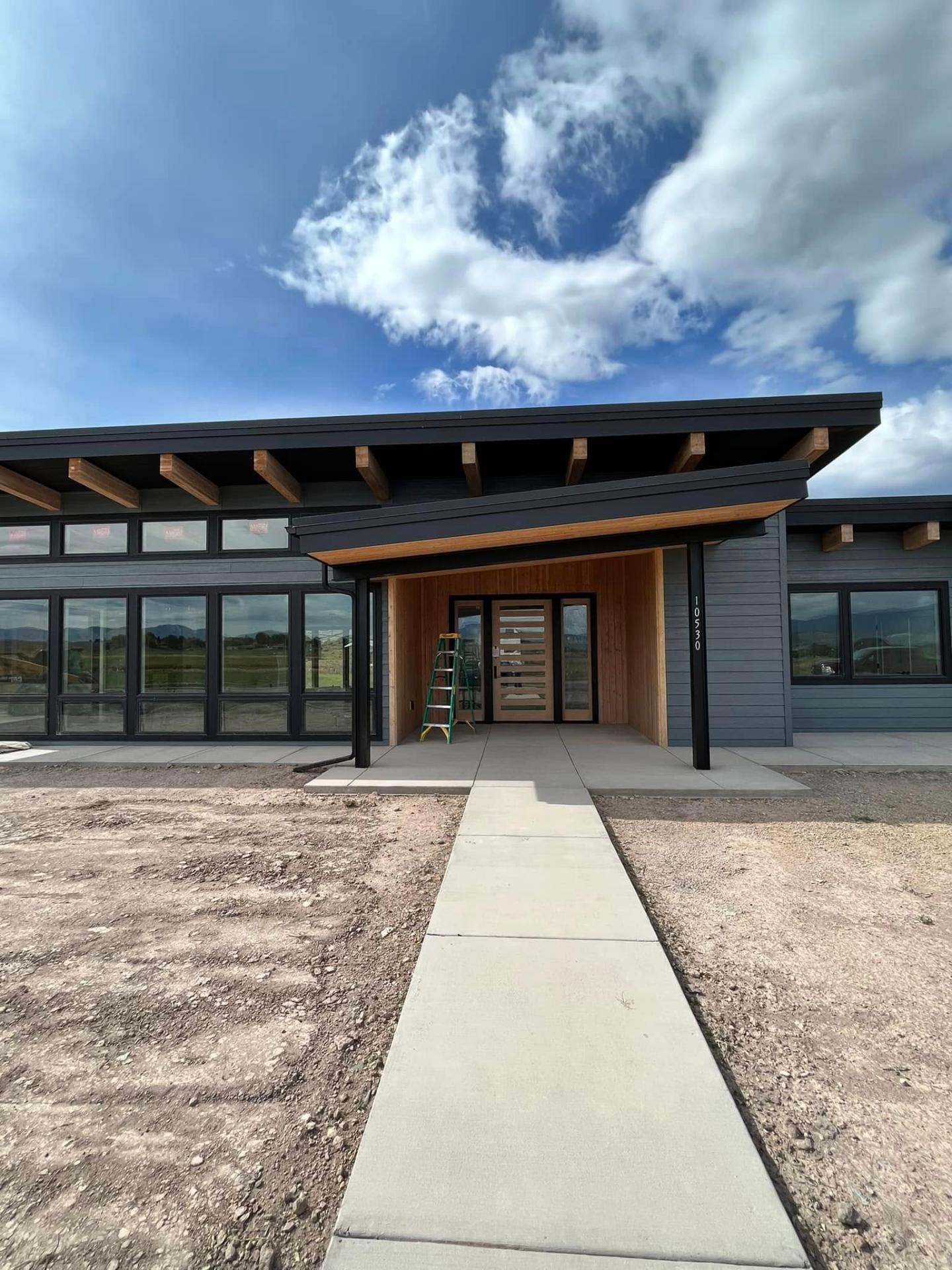 Front elevation of modern Missoula home with dark siding and cedar accents by Treeline Painting